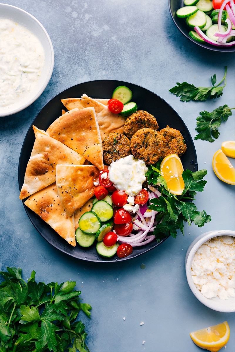 A plate filled with Air Fry Falafels, pita triangles, and tzatziki sauce
