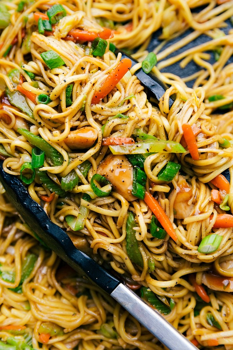 Image of the prepared Chicken chow Mein with tongs in the bowl.