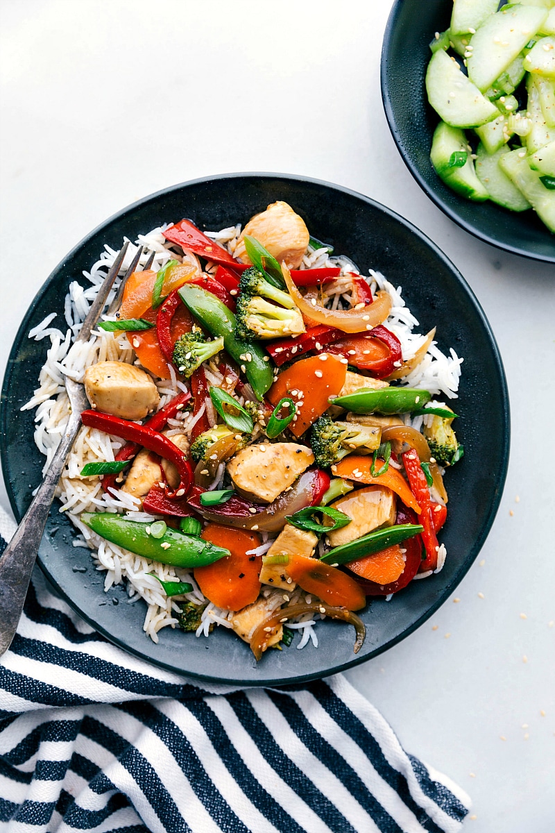 Image of Chicken Stir Fry in a bowl with rice and a fork on the side.