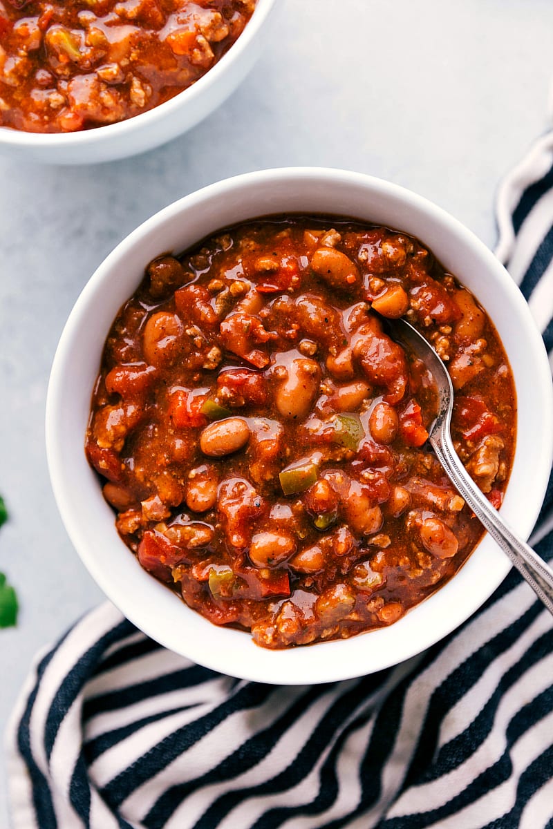 Overhead up-close photo of a bowl of spicy Crockpot Chili with a spoon digging in!