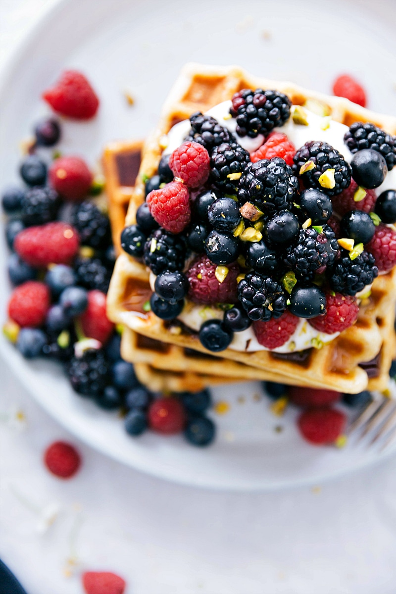 Overhead image of the cooked waffles stacked with berries on top.