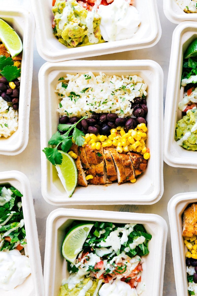 EASY MEAL PREP Chicken Burrito Bowls!! Tons of short-cuts for a better than a restaurant burrito bowl! Taco-seasoned chicken, cilantro-lime rice, salsa, guac, beans, and a creamy cilantro sauce! Recipe from chelseasmessyapron.com